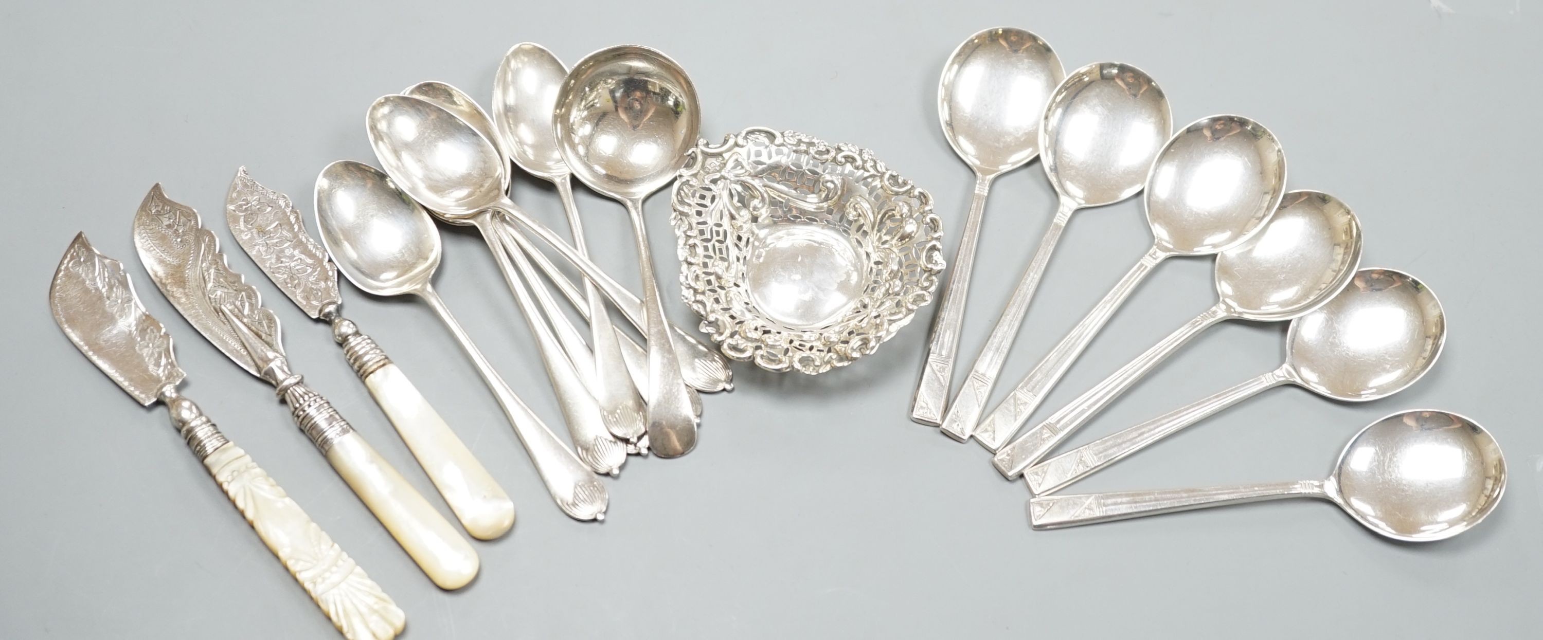 A late Victorian repousse silver bonbon dish, 91mm an assorted silver cutlery including three Victorian mother of pearl handled butter knives, a sauce ladle and two sets of six spoons including soup, weighable silver 11.